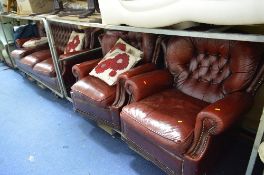 AN OX BLOOD LEATHER BUTTON BACK THREE PIECE SUITE, comprising of a three seater settee and a pair of