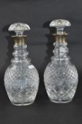 A PAIR OF GLASS DECANTERS, silver topped