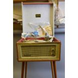 A DANSETTE BERMUDA RECORD PLAYER, on legs, pink and grey finish to case with stained beech tapered