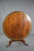 A REGENCY ROSEWOOD AND BRASS INLAID TILT TOP CENTRE TABLE, the circular top with a wide band of