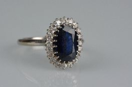 A LATE 20TH CENTURY SAPPHIRE AND DIAMOND OVAL CLUSTER RING, dark blue sapphire, measuring