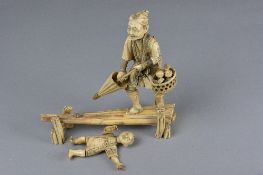 A LATE 19TH CENTURY JAPANESE IVORY FIGURE GROUP, of a child and a man on a narrow bridge, the man