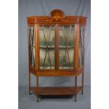 AN EDWARDIAN MAHOGANY AND INLAID DISPLAY CABINET, of triangular form, the cornice with central