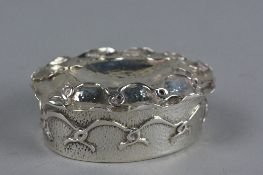 AN ARTS & CRAFTS OVAL SILVER BOX WITH HINGED COVER, hand hammered finish with overlaid scrolled