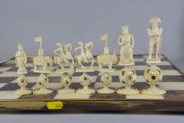 A 19TH CENTURY CANTONESE CARVED AND STAINED IVORY CHESS SET, puzzle ball bases, the white king