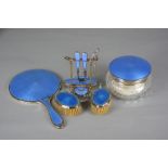 A GROUP OF MATCHED BLUE ENAMEL, SILVER AND PLATED DRESSING TABLE REQUISITES, comprising a glass