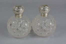 A PAIR OF EDWARDIAN SILVER MOUNTED HOBNAIL CUT SPHERICAL SCENT BOTTLES, hinged covers embossed