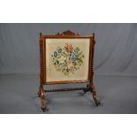 A VICTORIAN ROSEWOOD FIRESCREEN, carved top rail above a rectangular glazed panel containing a