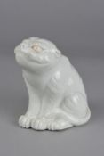 A JAPANESE HIRADO STYLE WHITE GLAZED PORCELAIN MODEL OF A SEATED TIGER, height approximately 15cm