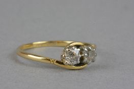 AN EARLY 20TH CENTURY TWO STONE DIAMOND CROSS OVER RING, two old cushion cut diamonds, estimated