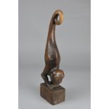 A CARVED HARDWOOD FIGURAL ORNAMENT, in the form of a two legged scaly lizard with monkey face,