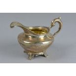 A WILLIAM IV SILVER CREAM JUG, of squat baluster form, gilt interior, cast 'S' scroll handle, on a