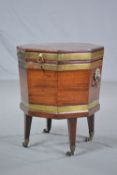 A GEORGE III MAHOGANY AND BRASS BOUND OCTAGONAL CELLARET, ring handle to front above lock, lead
