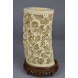 A LATE 19TH CENTURY IVORY BRUSH POT, with carved decoration of dragons on an intricately pierced