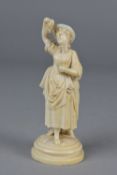 A 19TH CENTURY CARVED IVORY FIGURE OF A LADY WEARING HAT, holding a bunch of grapes above her mouth,