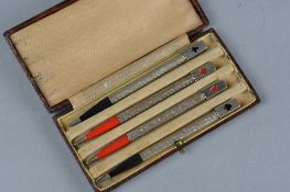 A CASED SET OF FOUR STERLING SILVER BRIDGE PENCILS, the square finials enamelled with card suit to