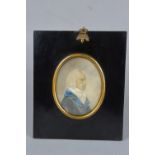 AN EARLY 19TH CENTURY PORTRAIT MINIATURE OF A GENTLEMAN, seated in profile, wearing a blue