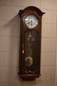 A MODERN MAHOGANY WALL CLOCK, signed AMS, Roman numerals, approximate height 105cm (winding handle)