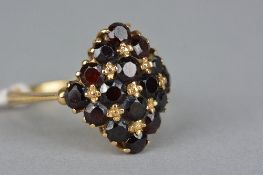A LATE 20TH CENTURY GARNET CLUSTER RING, sixteen round mixed cut garnets claw set in a diamond