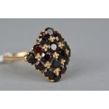 A LATE 20TH CENTURY GARNET CLUSTER RING, sixteen round mixed cut garnets claw set in a diamond