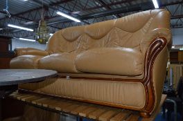 A TAN LEATHER TWO PIECE SUITE, comprising of a three seater settee and an armchair