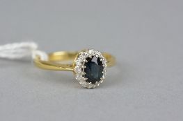 A LATE 20TH CENTURY 18CT GOLD SAPPHIRE AND DIAMOND OVAL CLUSTER RING, sapphire measuring