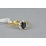 A LATE 20TH CENTURY 18CT GOLD SAPPHIRE AND DIAMOND OVAL CLUSTER RING, sapphire measuring