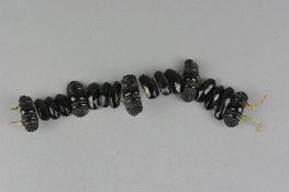 A JET BRACELET, assorted carved and faceted jet oval beads which have been strung to wire