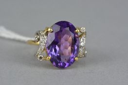 A MODERN DIAMOND AND AMETHYST DRESS RING, centring on a large oval mixed cut amethyst, measuring