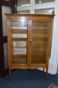 A 20TH CENTURY OAK GLAZED TWO DOOR DISPLAY CABINET, with four adjustable glass shelves on square