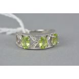 A MODERN 9CT WHITE GOLD DIAMOND AND PERIDOT DRESS RING, total modern round brilliant cut diamond