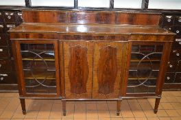 AN EDWARDIAN MAHOGANY BREAKFRONT ASTRAGAL GLAZED FOUR DOOR BOOKCASE, with raised back rail and