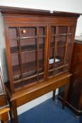 AN EDWARDIAN MAHOGANY GLAZED TWO DOOR BOOKCASE, on a seperate stand, approximate size width 102cm