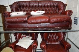 AN OX BLOOD LEATHER BUTTON BACK THREE PIECE SUITE, comprising of a three seater settee and a pair of