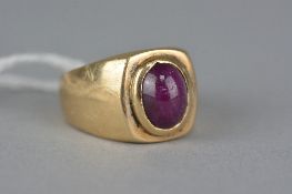 A MODERN GENT'S SINGLE STONE RUBY RING, an oval cabochon ruby measuring approximately 10mm x 8mm,