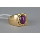 A MODERN GENT'S SINGLE STONE RUBY RING, an oval cabochon ruby measuring approximately 10mm x 8mm,