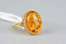A LATE 20TH CENTURY SINGLE STONE AMBER RING, oval cabochon amber measuring approximately 14mm x 10mm