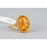 A LATE 20TH CENTURY SINGLE STONE AMBER RING, oval cabochon amber measuring approximately 14mm x 10mm