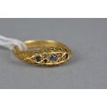 AN EARLY 20TH CENTURY SAPPHIRE AND DIAMOND DRESS RING, scroll design shoulders and open pierce