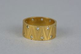 A MID TO LATE 20TH CENTURY 9CT GOLD SYNTHETIC WHITE SPINEL BAND RING, fully engraved in a