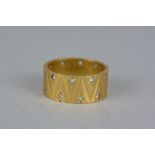 A MID TO LATE 20TH CENTURY 9CT GOLD SYNTHETIC WHITE SPINEL BAND RING, fully engraved in a