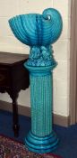 A BURMANTOFTS TURQUOISE GLAZED JARDINIERE ON STAND, the jardiniere in the form of a shell on a rocky