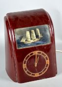A 1930'S VITASCOPE BURGUNDY BAKELITE CLOCK, with three masted ship in the glazed section,