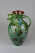 A C.H. BRANNAM BARUM WARE POTTERY JUG, green and blue glazed spout and decorated to one side with
