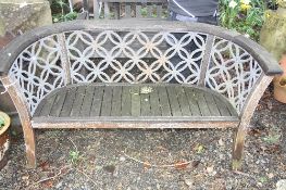A MODERN GARDEN BENCH, with wooden frame and fretwork metal panels to a curved back, 160cm long x