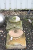 A PAIR OF SANDSTONE COLUMN BASES/TOPS, with foliage corners, 46cm square at base, 28cm diameter at