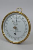 AN ANEROID BAROMETER, by Reynolds & Son, London, brass case, glazed front with hanging hook