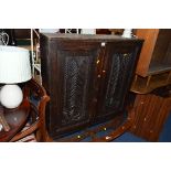 AN EARLY 20TH CENTURY OAK TWO DOOR HANGING CUPBOARD WITH CARVED DOORS, approximate size height