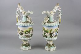 A PAIR OF CONTINENTAL PORCELAIN EWERS, figural handles, the bodies moulded with a continuous band of