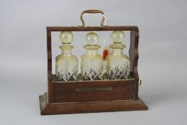 A MINIATURE THREE BOTTLED TANTALUS, height approximately 21cm x length approximately 23cm, with key